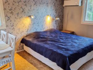 a bedroom with a blue comforter on a bed at 7 person holiday home in NYNÄSHAMN-By Traum in Nynäshamn +30 photos