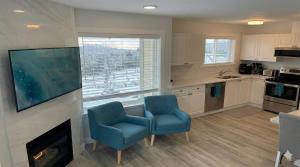 a kitchen with two blue chairs and a fireplace at True Ski-In-Ski-Out Rare 3-Bed Condo in Mount Washington