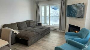 a living room with a couch and a fireplace at True Ski-In-Ski-Out Rare 3-Bed Condo in Mount Washington