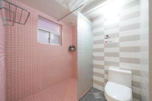 a bathroom with a toilet and a shower with pink tiles at MoMo Juice Busan Haeundae in Busan +47 photos