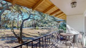 a porch with a table and chairs and a tree at Atlantic Breeze #8 in Jekyll Island