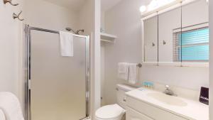 a bathroom with a shower and a toilet and a sink at Atlantic Breeze #8 in Jekyll Island +13 photos