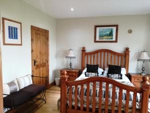 a bedroom with a wooden bed and a couch at Rosswood House in Donegal