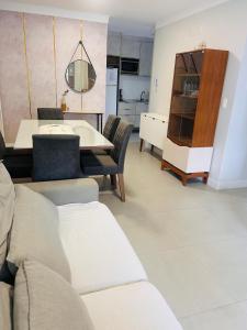 a living room with a table and a kitchen at Apartamento perto da Praia em Itapema!!! in Itapema
