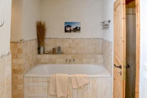 a bath tub in a bathroom with a tile wall at BEACHHOUSE Fehmarn in Fehmarn +13 photos