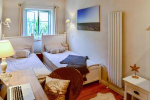a room with two beds and a desk with a laptop at BEACHHOUSE Fehmarn in Fehmarn