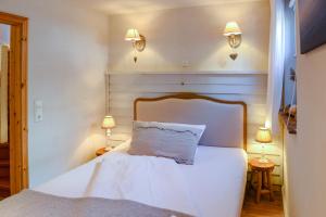 a bedroom with a white bed with two lamps at BEACHHOUSE Fehmarn in Fehmarn