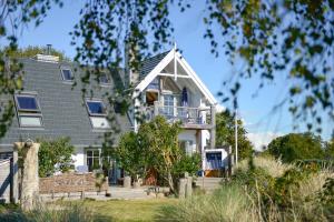 a white house with a gambrel roof at BEACHHOUSE Fehmarn in Fehmarn