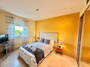 a bedroom with a large bed and a television at ApartSur® in Bormujos
