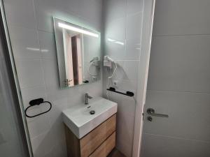 a white bathroom with a sink and a mirror at Escola in Ourense +20 photos