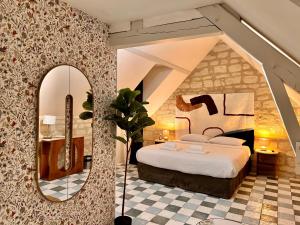 a bedroom with a large bed and a mirror at Logis Hotel Demeure de la Vignole in Turquant +82 photos