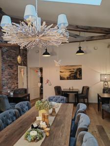 a dining room with a wooden table and blue chairs at Pension Kleiner König in Struppen-Siedlung