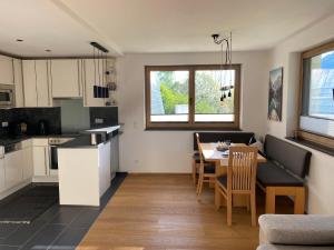 a kitchen and dining room with a table and chairs at Ferienwohnung Fotscherblick in Sellrain