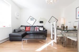 ロンドンにあるBEST LOCATION Central London Zone 1 Large 3 bedroom near all Attractionsのリビングルーム(黒いソファ、テーブル付)