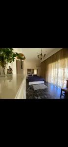 a bedroom with a bed and a couch and a window at Master private room in shared appartement in Athens