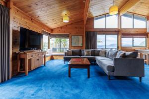 a living room with a couch and a tv at Koura Lodge in Rotorua