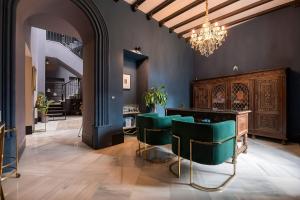 a salon with green chairs and a chandelier at Boutique Suites in Arcos de la Frontera