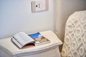 a book on a table next to a bed at Villa Il Lupo Felice - Panoramic Sea View Villa, Ravello in Ravello
