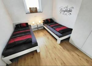 two beds in a room with wooden floors at Ferienhof Broger FeWo Bergblickle mit Pool in Neukirch +59 photos