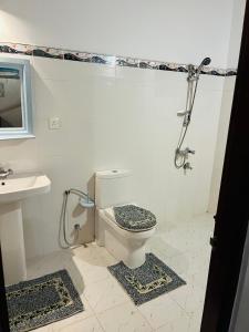 a bathroom with a toilet and a sink and a shower at Hikka Magnoon Villa in Hikkaduwa