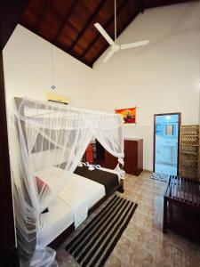 a bedroom with a bed with a mosquito net at Hikka Magnoon Villa in Hikkaduwa