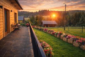 a porch of a house with flowers and a sunset at Dom u Teresy in Harkabuz