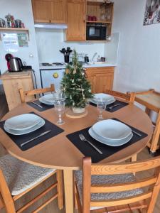 a dining room table with a christmas tree on it at L'esquirol ! in Les Angles +18 photos