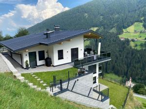 a house on top of a hill with a balcony at Ferienwohnung Fotscherblick in Sellrain