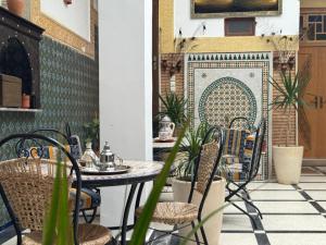 an outdoor patio with a table and chairs at Riad Dar Fassi in Rabat