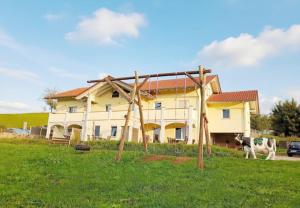 a cow standing in front of a house at Ferienhof Broger FeWo Bergblickle mit Pool in Neukirch