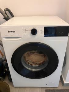 a white washing machine sitting in a room at Garsoniera Goldis in Arad