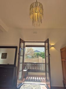 a chandelier hangs above a door to a balcony at Open plan apartment in Muizenberg in Muizenberg