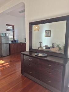 a living room with a large mirror on a dresser at Open plan apartment in Muizenberg in Muizenberg