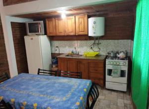 a kitchen with a table and a white refrigerator at Mi Niña's in Villa Cura Brochero