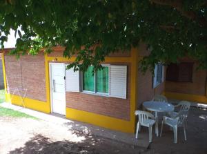 a table and chairs in front of a building at Mi Niña's in Villa Cura Brochero
