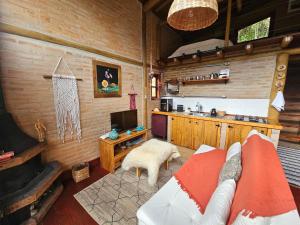 a living room with a couch and a kitchen at Recanto Curiaçu in Cunha