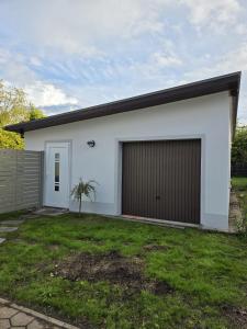 a white house with a large garage at Ferienhaus Lyś in Lauta