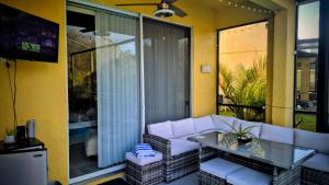 a living room with a white couch and a glass table at NO DAY OF BOOKING 24 HOURS NOTICE One private Master Efficency Suite Room with Bathroom for one person or couple with a pool breakfast included message here or email Floridastylz74 g mail com in Davenport