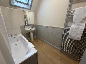a bathroom with a bath tub and a sink at Roods Apartment in Angus