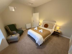 a bedroom with a large bed and a chair at Roods Apartment in Angus