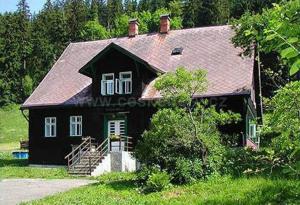 a black house with a red roof at Chalupa U Bertholda in Červená Voda