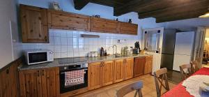 a kitchen with wooden cabinets and a microwave at Chalupa U Bertholda in Červená Voda