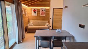 a dining room with a table and chairs and a couch at LA CASETTA - Appartamento CERVINO in Torgnon