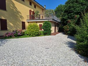 a house with a balcony and a gravel driveway at Residence Casa del Moro in Minerbio