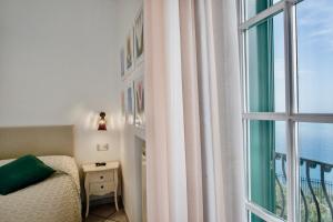 a bedroom with a bed and a large window at Villa Il Lupo Felice - Panoramic Sea View Villa, Ravello in Ravello