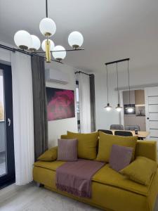 a yellow couch in a living room with a kitchen at Deluxe 3 in Timişoara
