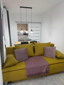 a yellow couch with pillows in a living room at Deluxe 3 in Timişoara +8 photos