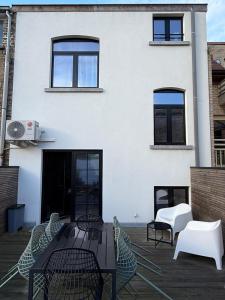a patio with tables and chairs in front of a building at De Bakelijn in Nieuwpoort
