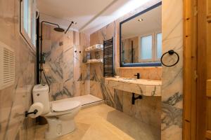 a bathroom with a toilet and a sink and a mirror at Boutique Suites in Arcos de la Frontera