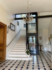 a room with a staircase and a chandelier at Château de Saint-Bohaire in Saint-Bohaire